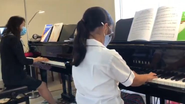 Student practising on a Yamaha grand piano